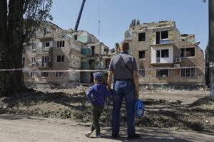 Un padre y su hijo observan este viernes el lugar donde un ataque ruso alcanzó ayer un edificio residencial de cinco plantas en Kiev (Ucrania). Al menos 23 personas murieron, entre ellas cuatro niños, y 50 resultaron heridas en el ataque nocturno ruso sobre Ucrania. EFE/ Sergey Dolzhenko