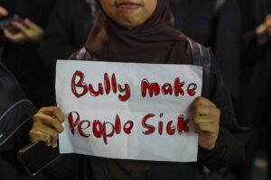 Imagen de archivo tomada el 15 de agosto en Kuala Lumpur, Malasia, que muestra a una mujer sujetando un cartel en solidaridad con Zara Qairina, una niña de 13 años que sufría acoso escolar y murió el 17 de julio, un día después de ser hallada inconsciente en un desagüe cerca de su colegio. EFE/EPA/FAZRY ISMAIL