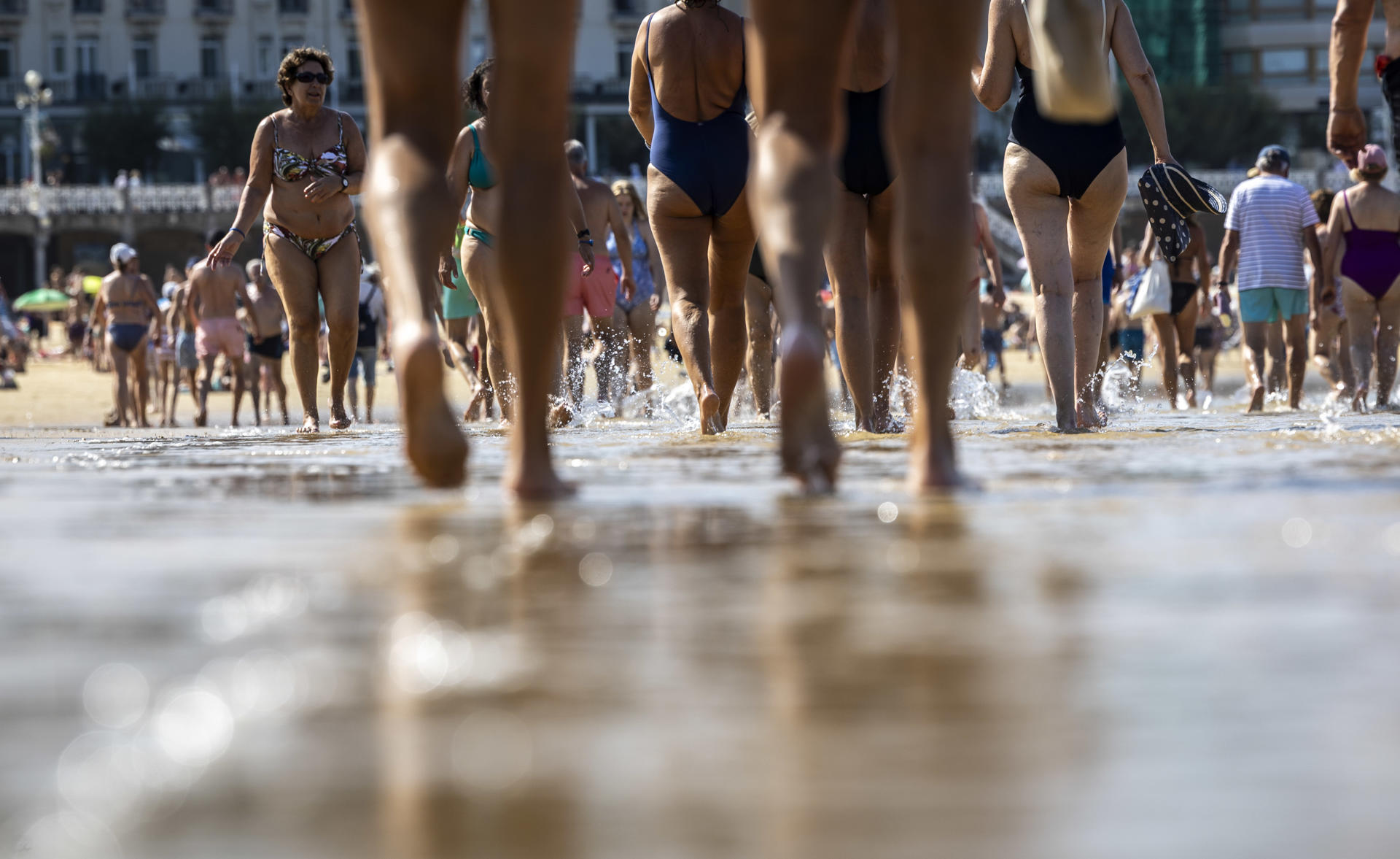 Numerosas personas paseando por la orilla de la playa de La Concha de San Sebastián este jueves, donde se esperan temperaturas superiores a 30ºC. EFE/Javier Etxezarreta