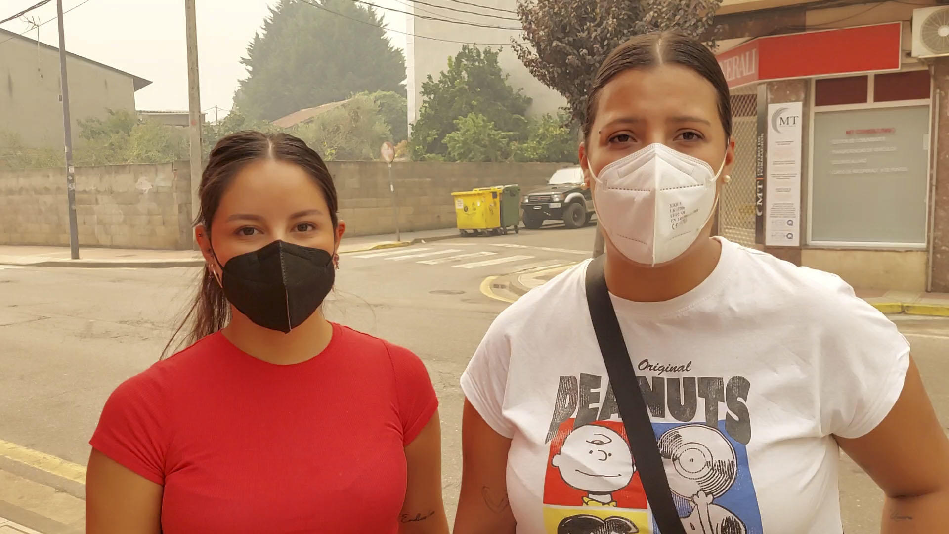 A Dos personas posan con mascarillas para protegerse del humo de los incendios este sábado, en A Rúa (Ourense). El humo de los incendios forestales y una nube tóxica derivada del punto limpio que se vio afectado por el fuego en A Rúa, en la parte oriental de la provincia de Ourense, ha obligado a los vecinos a recuperar las mascarillas que quedaban en casa después del Covid. EFE/ Carlos Alberto Fernández