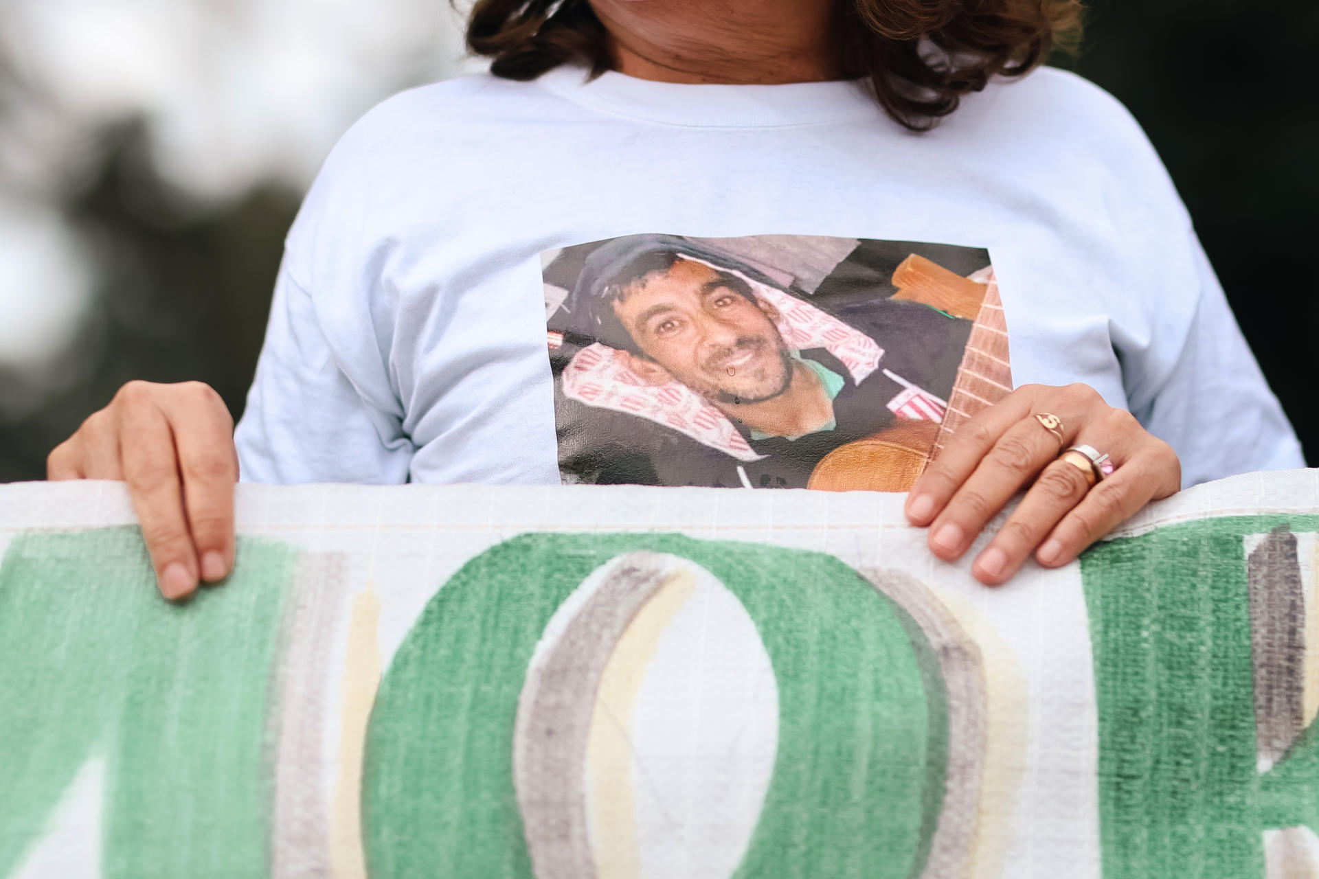 Fotografía donde se observa al familiar de Daniel Sebastían Oviedo portando una imagen del joven, victima mortal por el uso de fentanilo, durante una manifestación este jueves, frente al Hospital Italiano de La Plata, en La Plata (Argentina). EFE/ Juan Ignacio Roncoroni