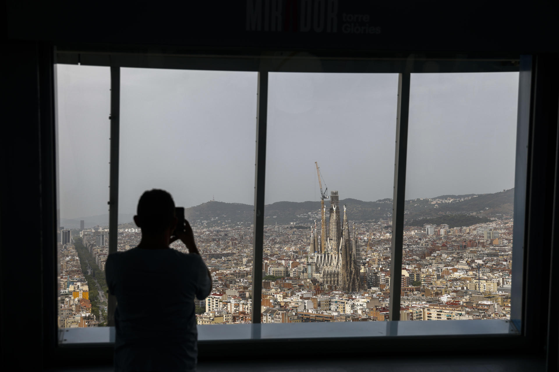 Una persona divisa las vistas de Barcelona desde el Mirador Torre Glòries que acogerá del 2 al 5 de septiembre la 36 edición de la Convención Anual de la World Federation of Great Towers (WFGT), la "Champions League" de las torres más icónicas del mundo, a la que asistirán los representantes de 26 de las 55 torres que forman parte de la federación. EFE/Quique García