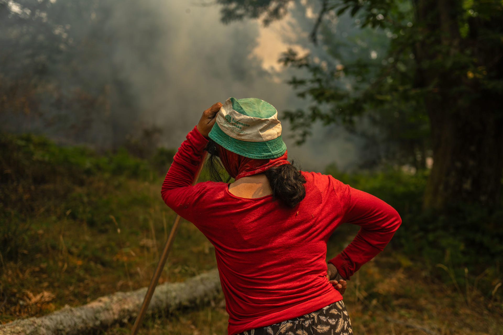 Una vecina de la aldea de Pareisás lucha contra en fuego en el incendio forestal que permanece activo en A Pobra de Trives (Ourense). EFE/Brais Lorenzo