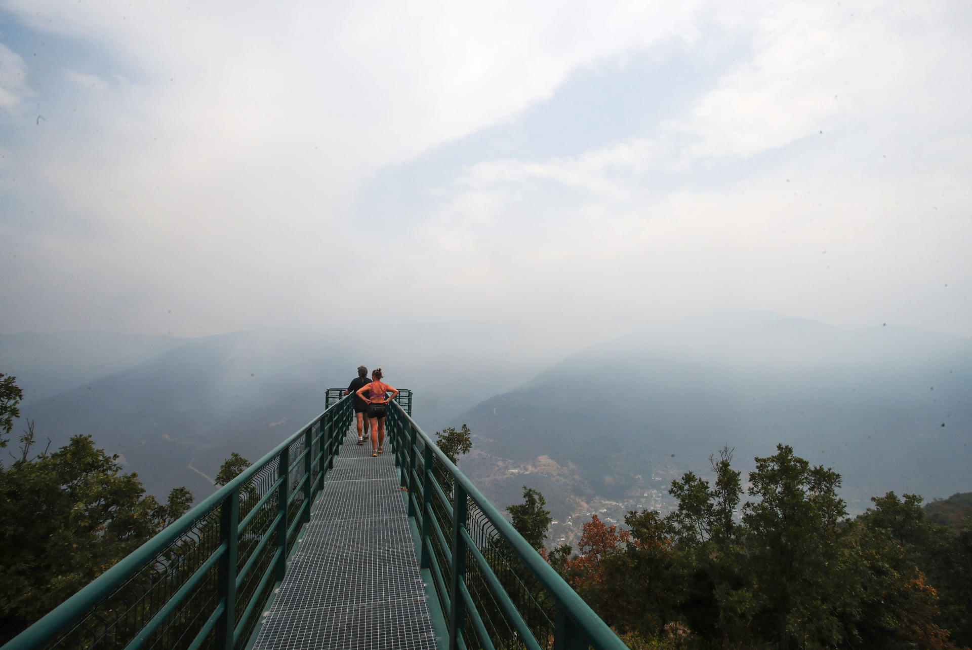 Dos personas observan este martes, el incendio cercano a la localidad de Pombriego (León). EFE/ Ana F. Barredo
