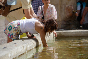 Una mujer se refresca en una de las fuentes del Patio de los Naranjos de la Mezquita Catedral de Córdoba este viernes, jornada marcada por las altas temperaturas. EFE/Salas