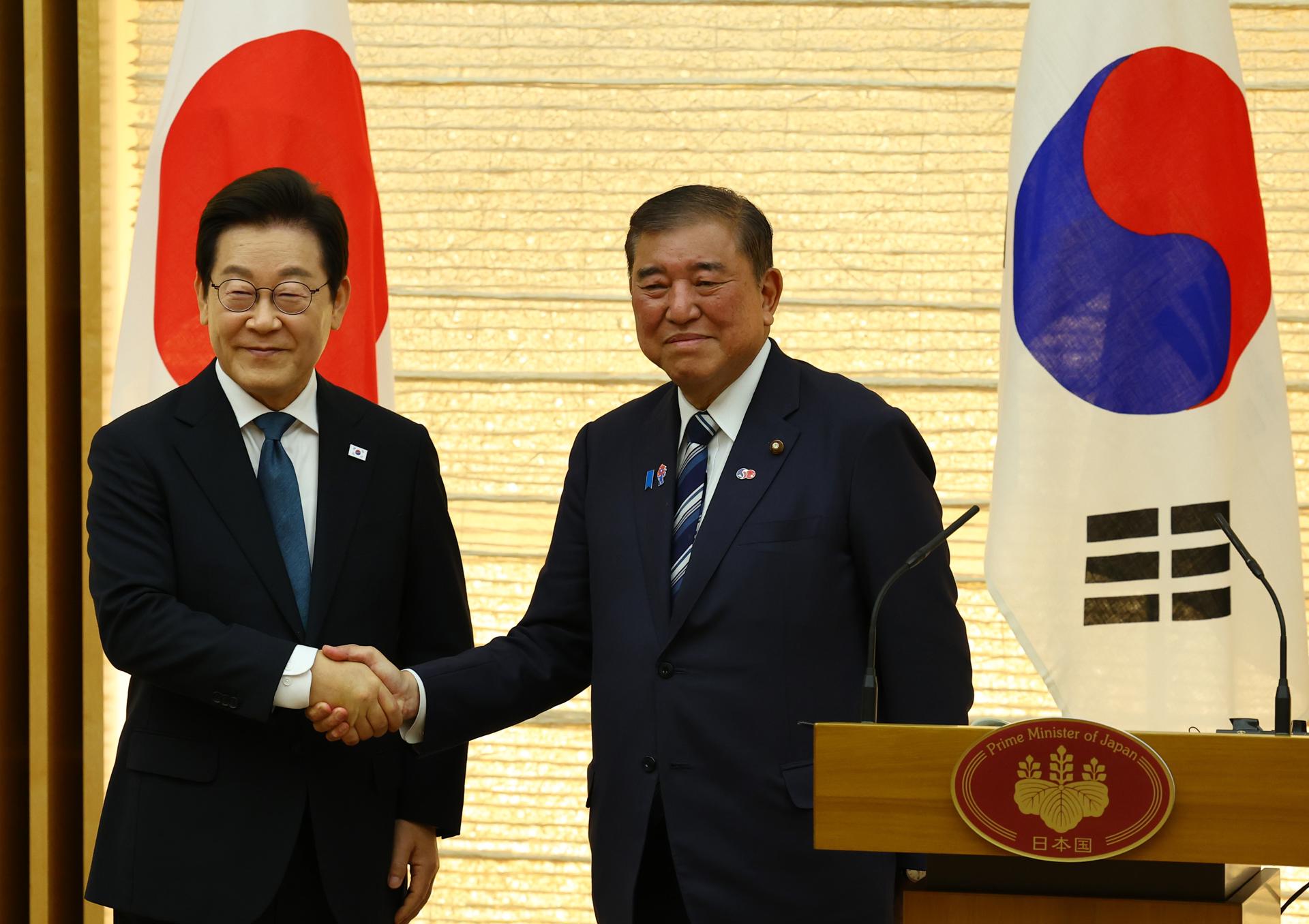 El presidente de Corea del Sur, Lee Jae Myung (i), y el primer ministro de Japón, Shigeru Ishiba, al estrechar sus manos, este sábado, 23 de agosto, en Tokio (Japón). EFE/Kim Kyung-Hoon/Pool