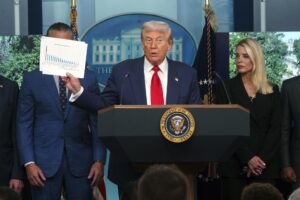 El presidente de EE.UU., Donald Trump (C), sostiene un documento mientras se dirige a los medios en la sala de prensa James S. Brady de la Casa Blanca, en Washington. EFE/Will Oliver