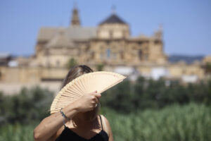 Una turista se abanica en el puente romano de Córdoba este viernes. El puente de agosto comienza con España inmersa en una larga ola de calor. EFE/ Salas