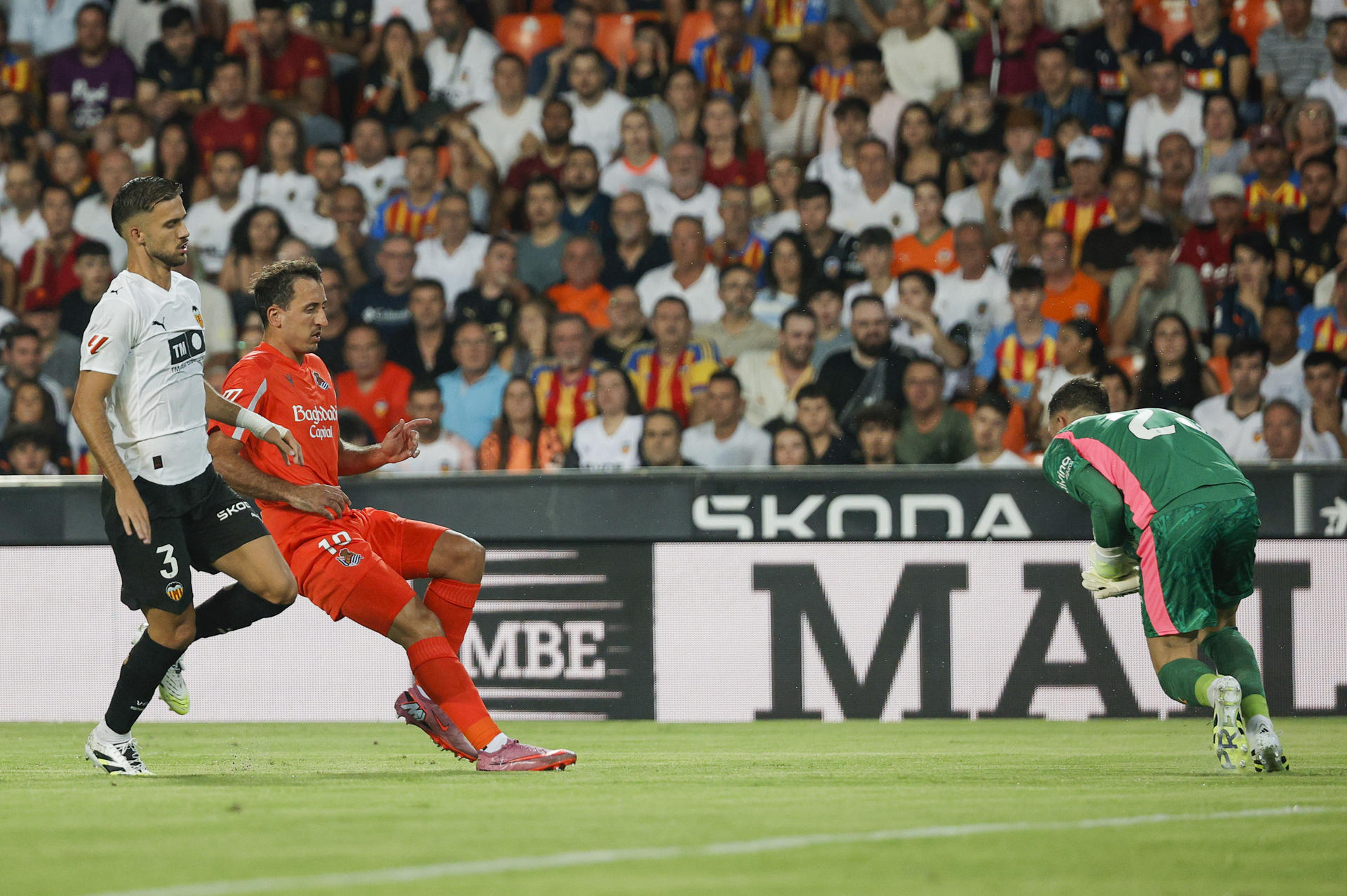 El guardameta del Valencia Julen Agirrezabala (d) atrapa el balón ante el delantero de la Real Sociedad Mikel Oyarzabal (2i) durante el partido de la primera jornada de LaLiga entre Valencia CF y Real Sociedad, en el estadio de Mestalla, en Valencia. EFE/ Manuel Bruque