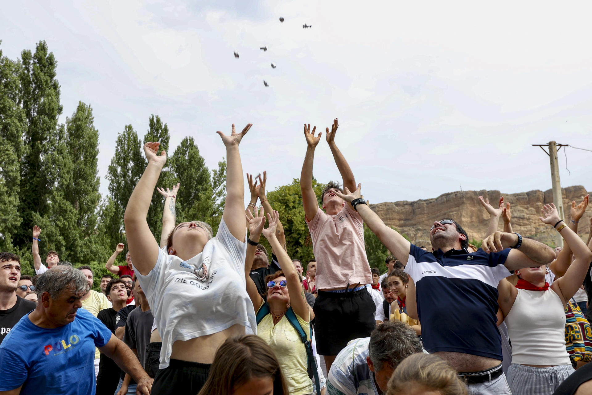 Unas 2.000 personas se han congregado este miércoles frente a la ermita de la Santa Cruz de Quel para conseguir los 2.500 bollos de pan y 60 kilos de queso de Roncal troceado en porciones que les han lanzado para revivir, como cada 6 de agosto, una tradición que data de 1479. EFE/ Raquel Manzanares