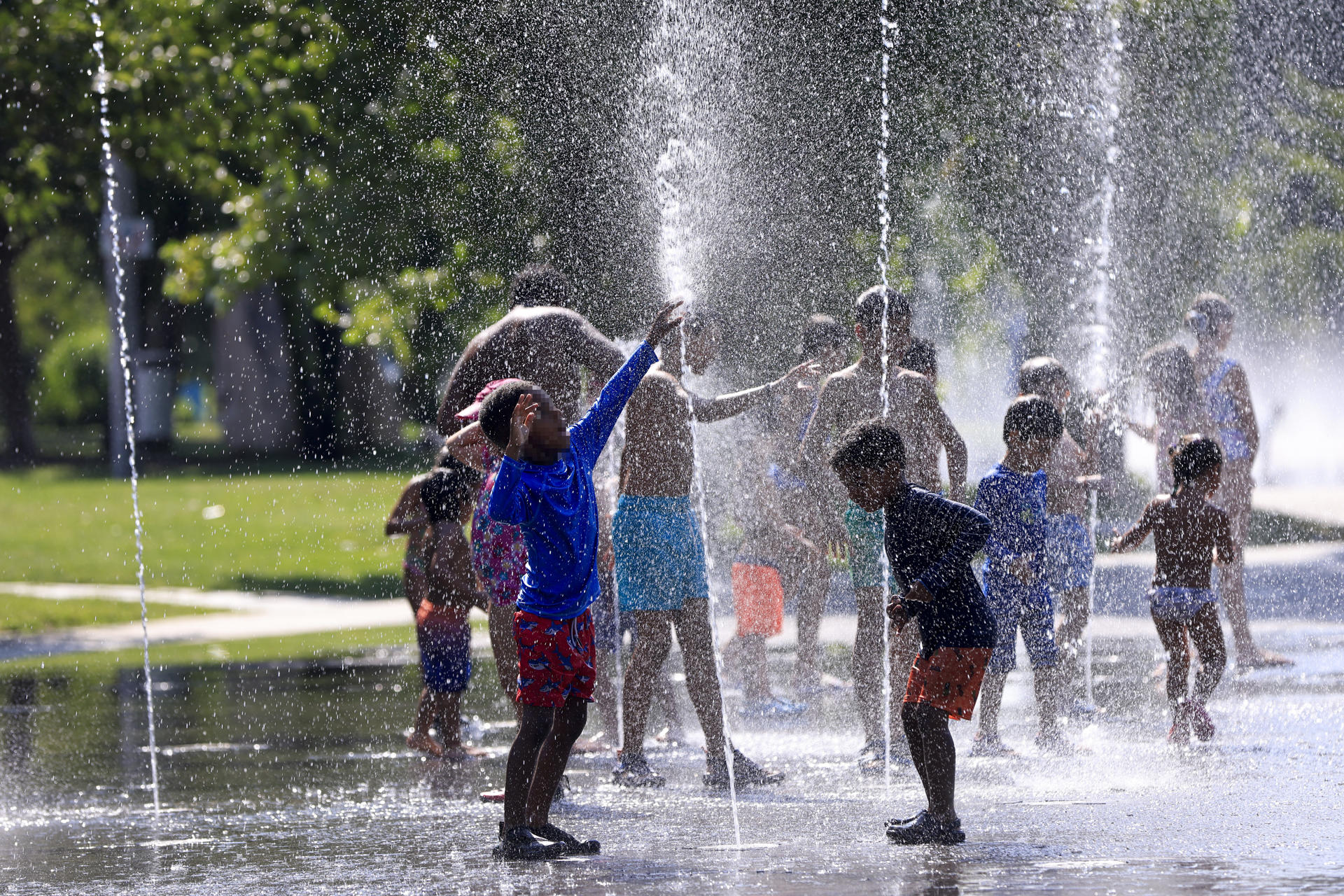 Un grupo de niños se refresca en los chorros de agua de Madrid Río este martes. EFE/ Pablo R. Seco
