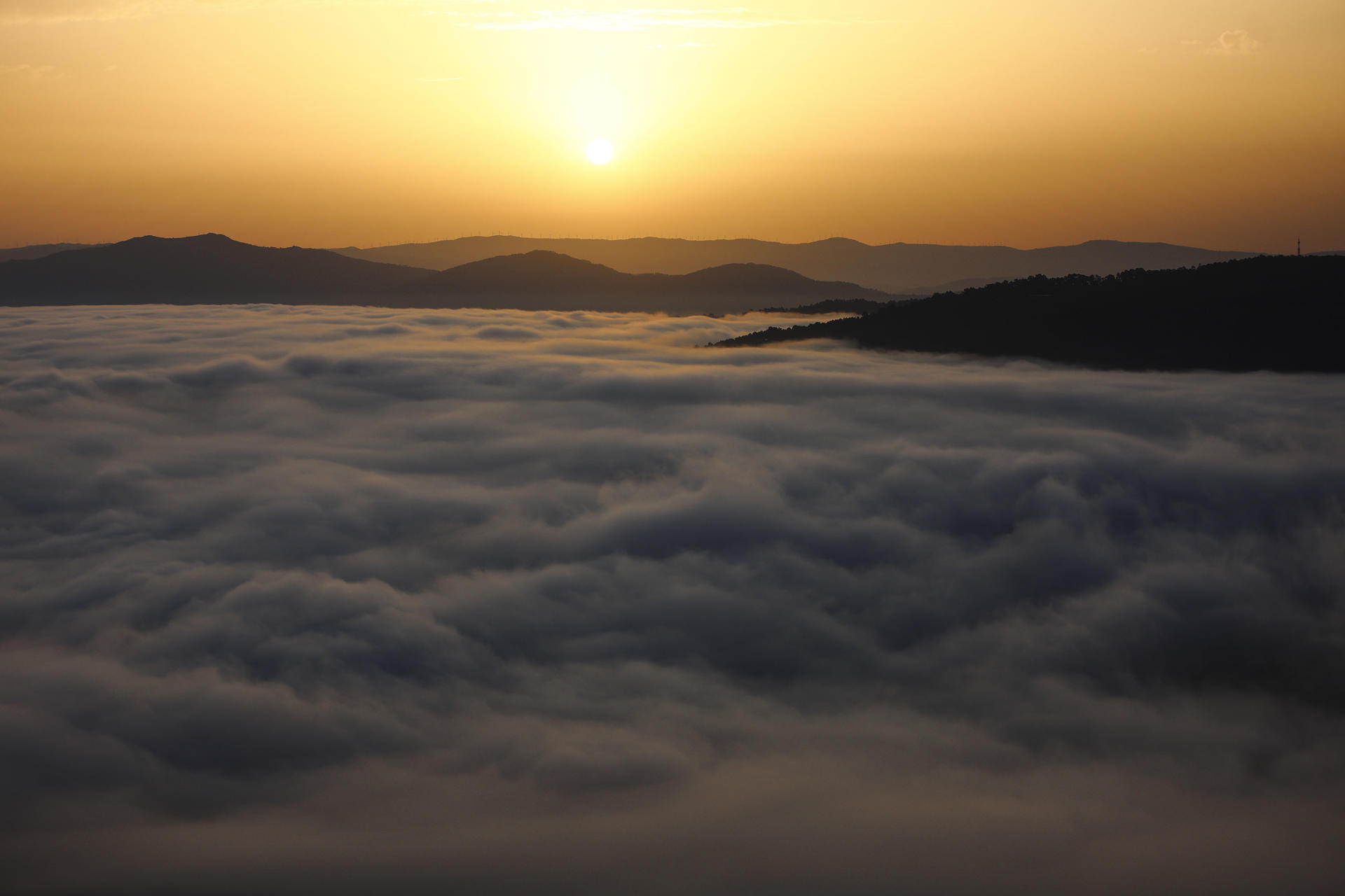 Un mar de nubes cubre la ciudad de Vigo en el amanecer de este lunes visto desde el monte Alba. EFE/sxenick
