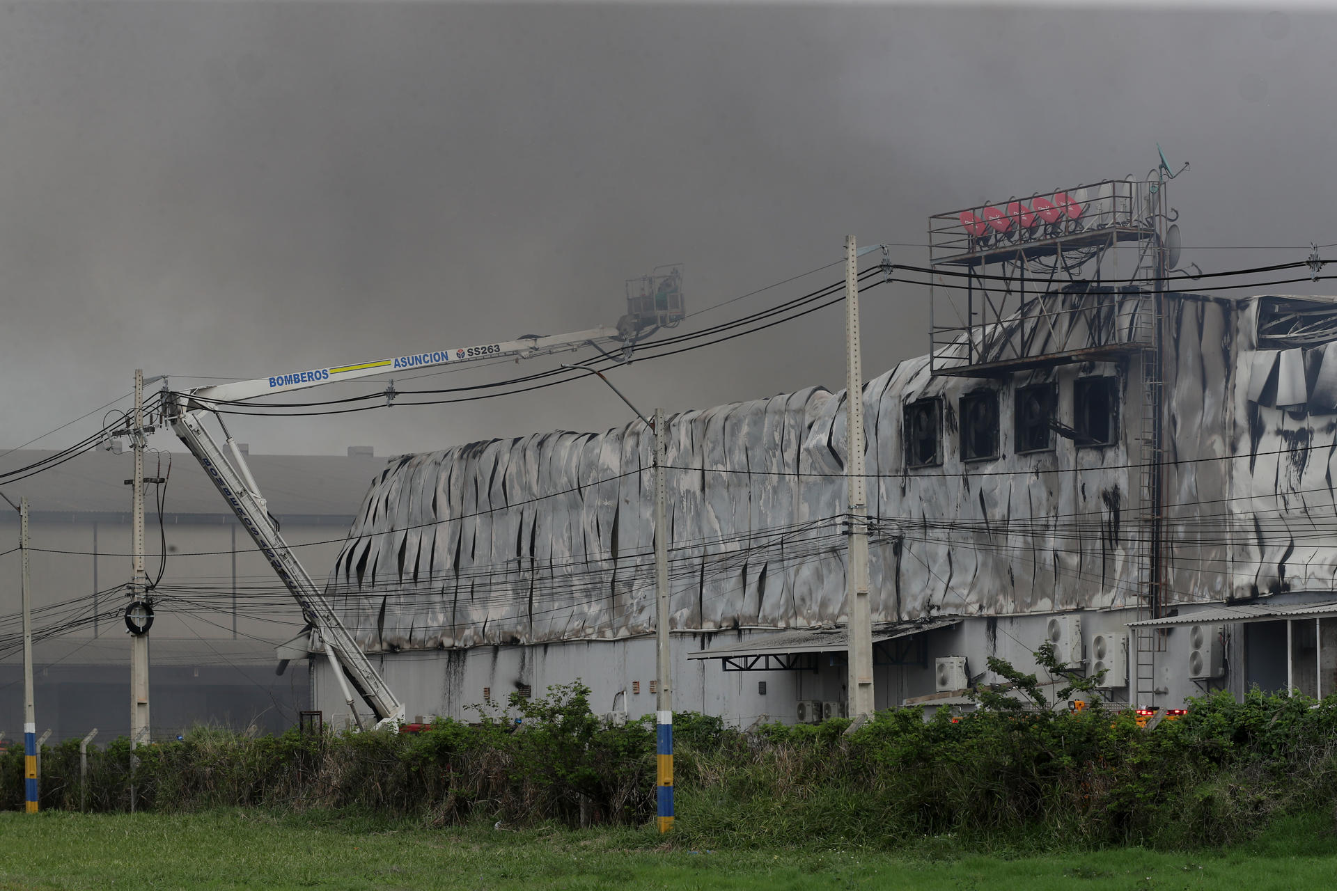 Integrantes del cuerpo de bomberos de Paraguay intentan apagar un incendio este domingo, en el Parque Industrial Logístico Nuestra Señora de la Asunción, en Luque (Paraguay). EFE/ Juan Pablo Pino