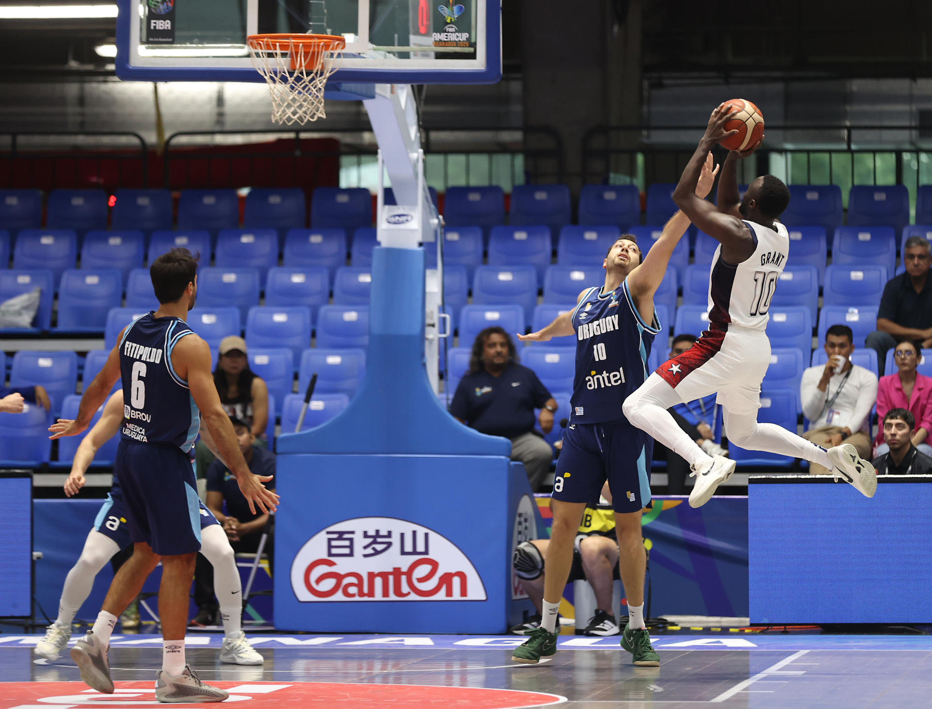 Jerian Grant (d), de Estados Unidos, intenta lanzar el balón ante la marca de Emiliano Serres, de Uruguay, en los cuartos de final de la FIBA AmeriCup 2025 en Managua (Nicaragua). EFE/STR
