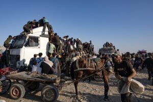 Palestinos desplazados internos se suben a un camión de ayuda humanitaria para conseguir comida cerca de un punto de distribución de alimentos en el corredor de Morag, al sur de Jan Yunis, en el sur de la Franja de Gaza, en una imagen del 4 de agosto de 2025. EFE/EPA/HAITHAM IMAD