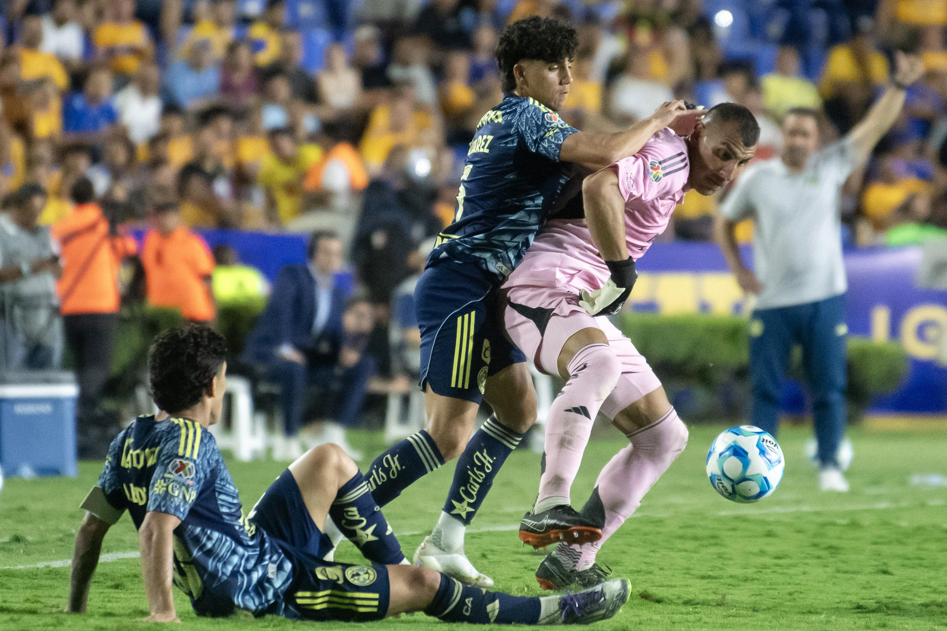 Nahuel Guzmán (d) de Tigres disputa el balón con Kevin Álvarez (c) de América este sábado, durante un partido del Torneo Apertura 2025 de la Liga MX en el estadio Universitario en Monterrey (México). EFE/Miguel Sierra
