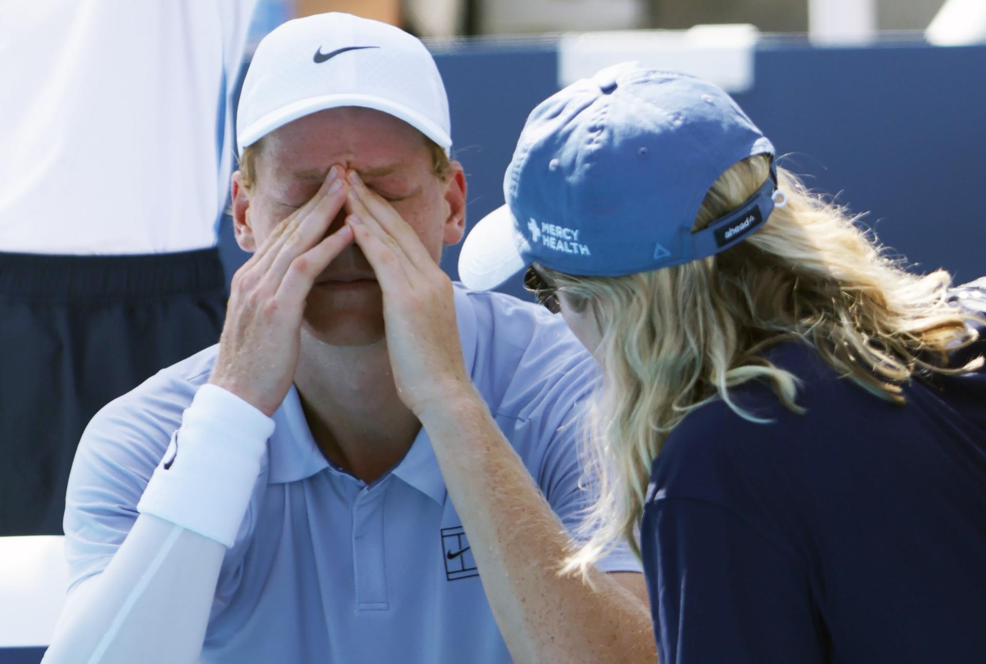Jannik Sinner (i) habla con el personal médico del torneo antes de retirarse por enfermedad de la final del Abierto de Cincinnati. EFE/EPA/MARK LYONS