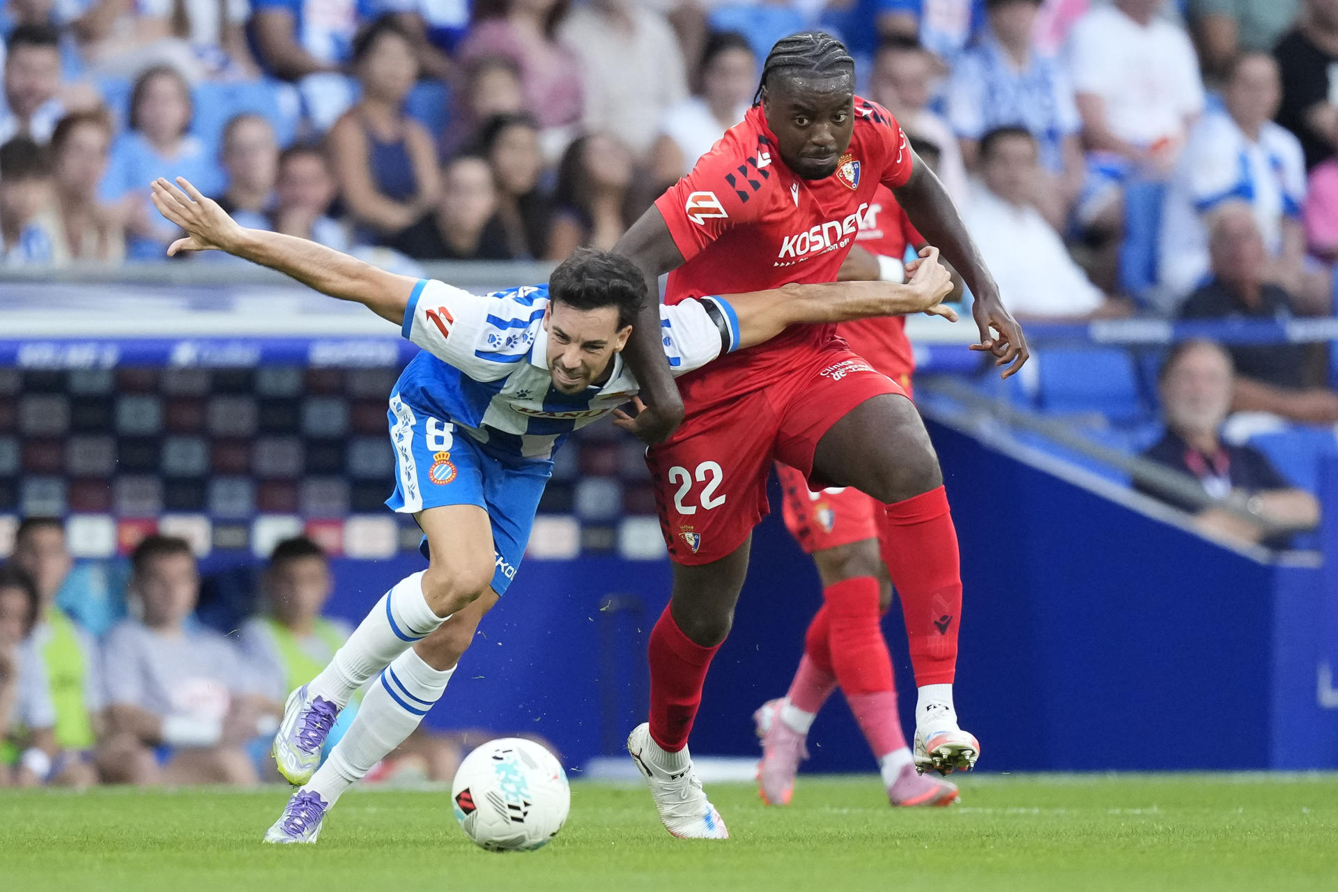 El centrocampista del Espanyol Eduardo Expósito (i) lucha con el francés Flavien-Enzo Boyomo, de Osasuna, durante el partido de la tercera jornada de LaLiga que RCD Espanyol y Atlético Osasuna juegan este domingo en el RCDE Stadium. EFE/Enric Fontcuberta