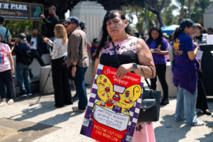 Fotografía cedida por la Coalición por los Derechos Humanos de los Inmigrantes (CHIRLA) que muestra a la ciudadana estadounidense Reyna posando con un cartel este martes, en Los Ángeles (Estados Unidos). EFE/ Coalición por los derechos humanos de los inmigrantes