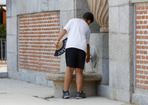 Un joven se refresca en una fuente, este viernes en Madrid. Una nueva ola de calor azotará previsiblemente desde este domingo gran parte de la península, especialmente el centro y la mitad sur, hasta al menos el próximo martes, cuando se espera "el día más caluroso del episodio", con temperaturas que podrían rondar los 44 grados en algunos casos. EFE/ Mario Moron