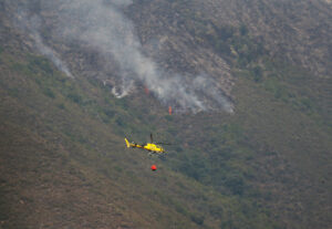 Helicópteros trabajan este martes, en la extinción del incendio cercano a la localidad de Pombriego (León). EFE/ Ana F. Barredo