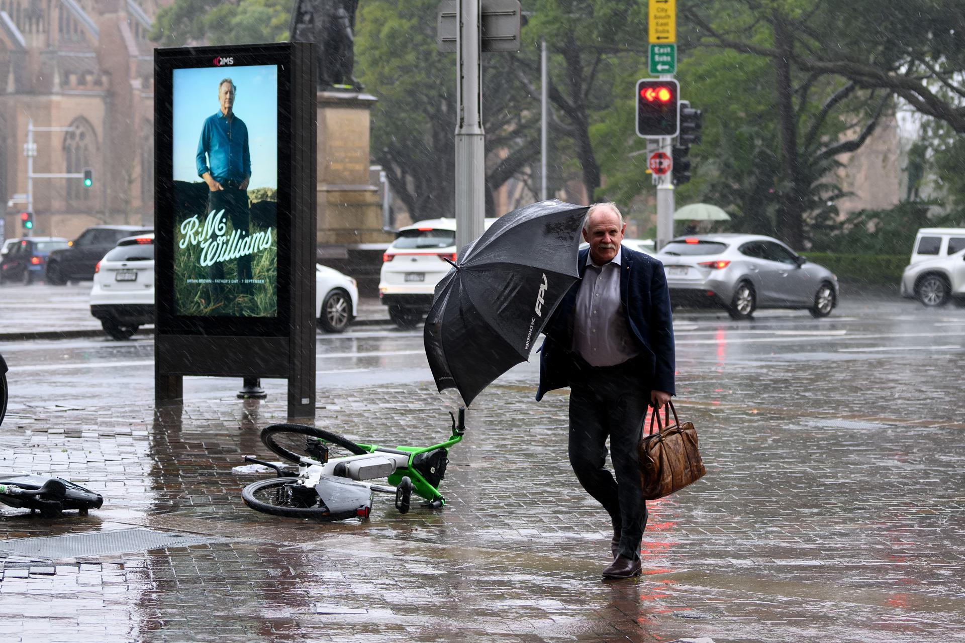 Un hombre bajo la lluvia en Sídney. 
EFE/EPA/STEVE MARKHAM AUSTRALIA AND NEW ZEALAND OUT
