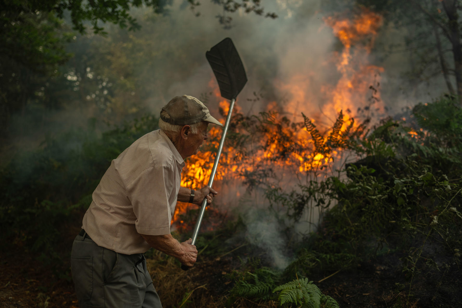 Un vecino de la aldea de Pareisás lucha contra en fuego en el incendio forestal que permanece activo en A Pobra de Trives (Ourense). EFE/Brais Lorenzo
