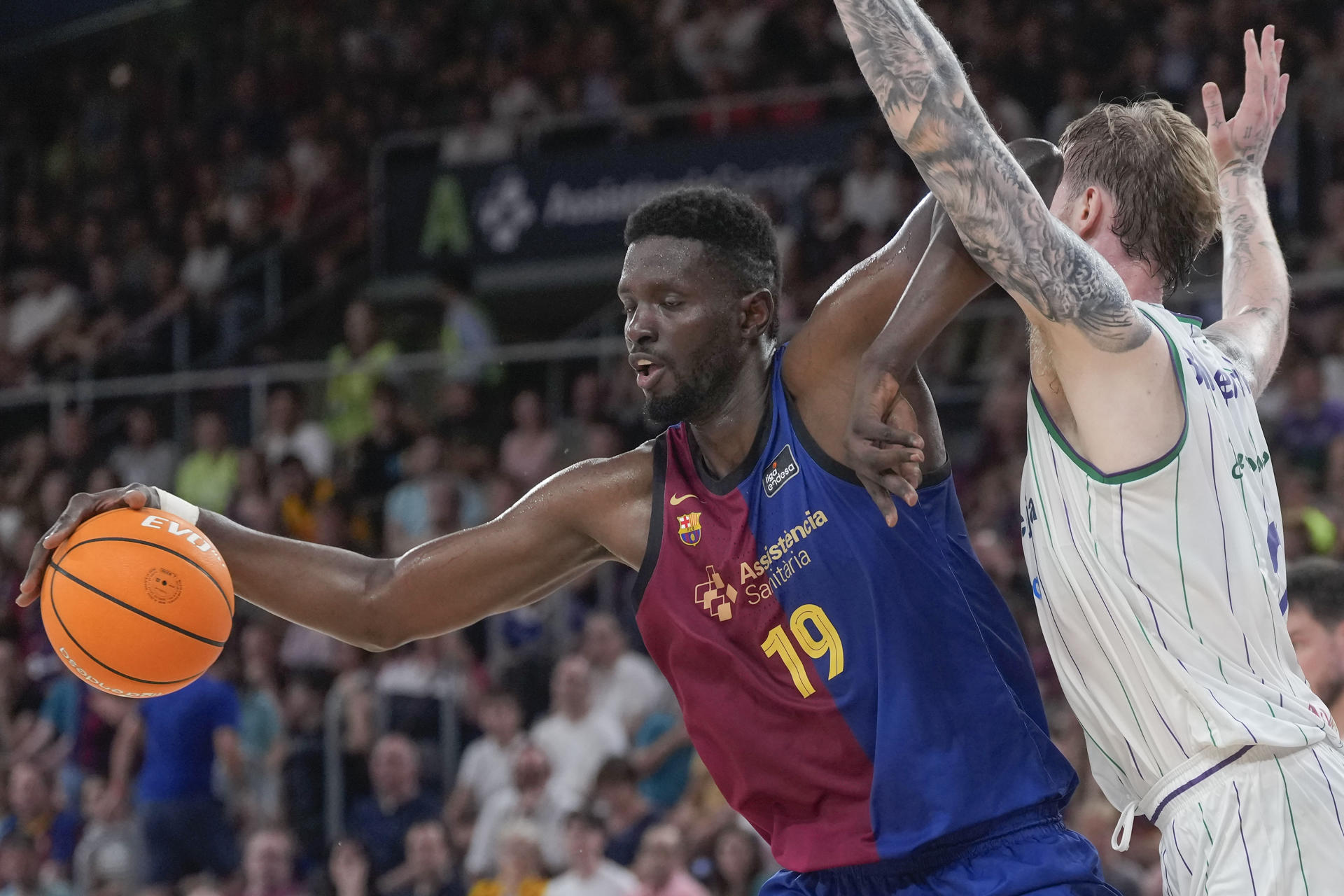 El pívot senegalés del Barcelona Youssoupha Fall pugna or el balón con el jugador polaco de Unicaja Olek Balcerowski (d), durante el segundo partido de los cuartos de final de la Liga Endesa. EFE/ Enric Fontcuberta.