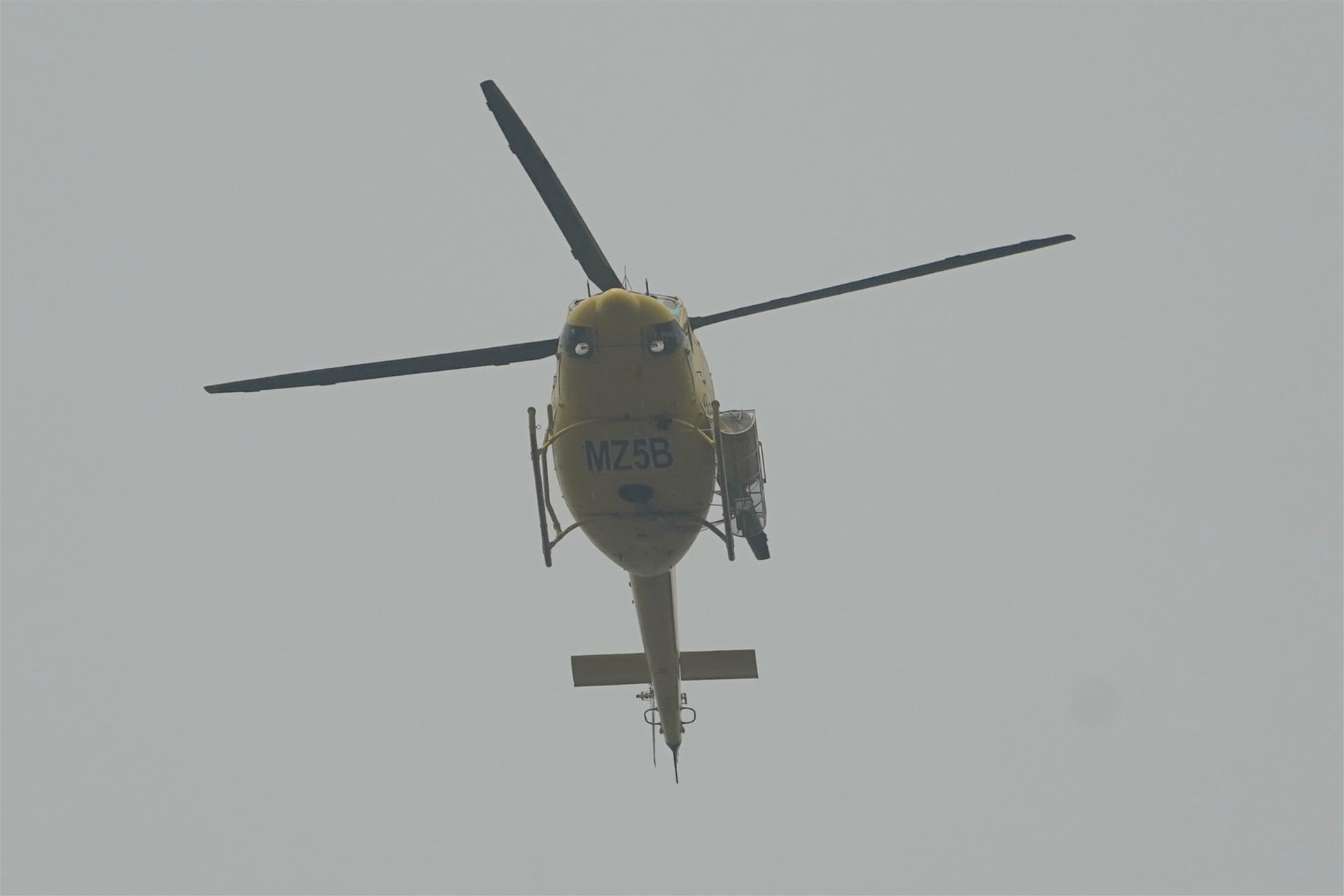 Un helicóptero se dirige a la zona de los incendios en Cangas del Narcea, este domingo. EFE/Paco Paredes
