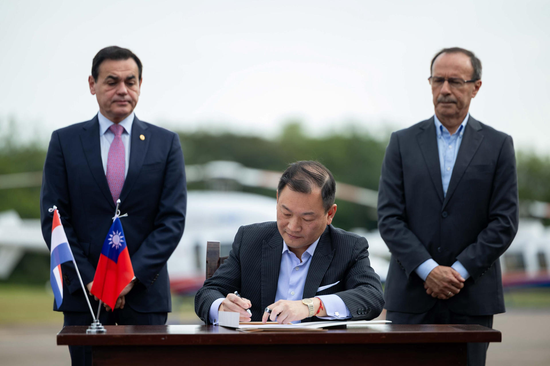 Fotografía cedida por la Presidencia de Paraguay que muestra al embajador de Taiwán en Asunción, José Chih-Cheng Han (c), firmando un acta junto al canciller de Paraguay, Rubén Ramírez (i), y el ministro de Defensa de Paraguay, Oscar González, este jueves, en la Base Aérea Ñu Guasu en Luque (Paraguay). EFE/ Presidencia de Paraguay
