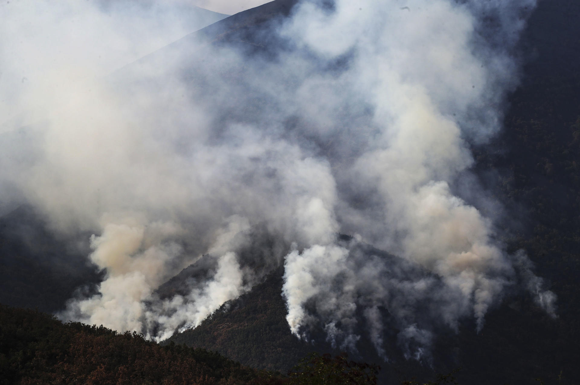 La bajada de las temperaturas, el aumento de la humedad y el refuerzo de los medios han permitido una mejora notable de la situación de los incendios en Castilla y León, que mantiene 16 de gravedad 1 y 2, con la vista puesta en Porto (Zamora), en el Parque Natural del Lago de Sanabria y en la zona norte de León. En la imagen, incendio en Compludo. EFE/Ana F. Barredo