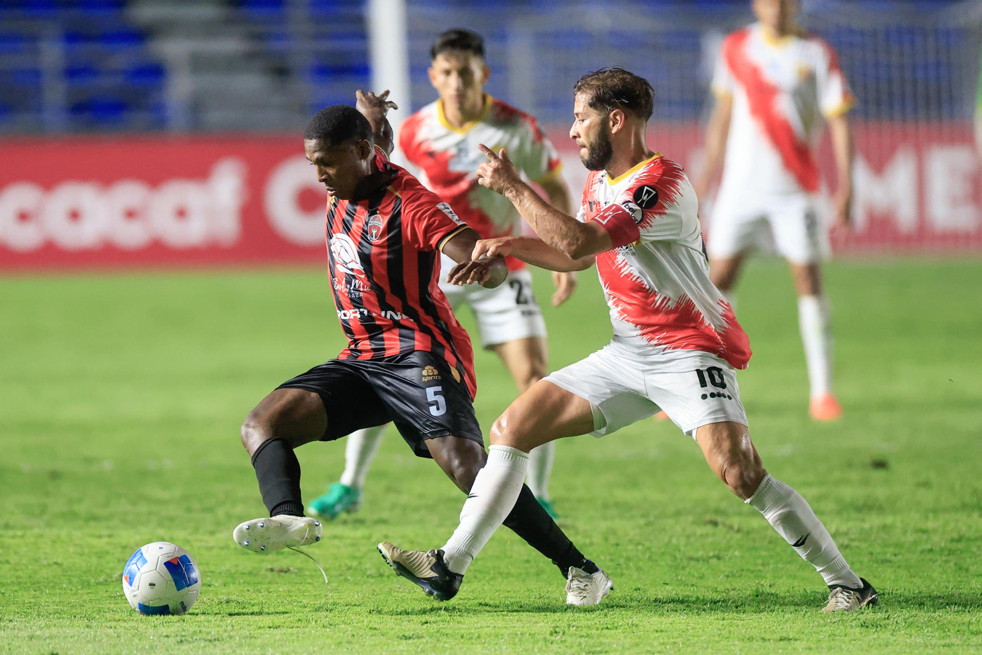 Armando Cooper (i) de San Miguelito disputa el balón con Elías Aguilar de Herediano este jueves, durante un partido de la fase de grupos de la Copa Centroamericana Concacaf. EFE/Bienvenido Velasco
