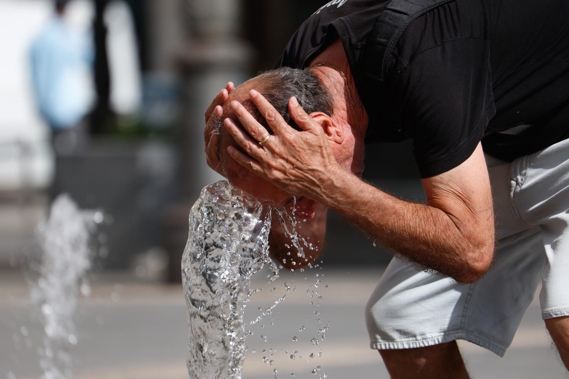 Un hombre se refresca en una de las fuentes del centro de Córdoba este viernes, una jornada marcada por las altas temperaturas. EFE/Salas