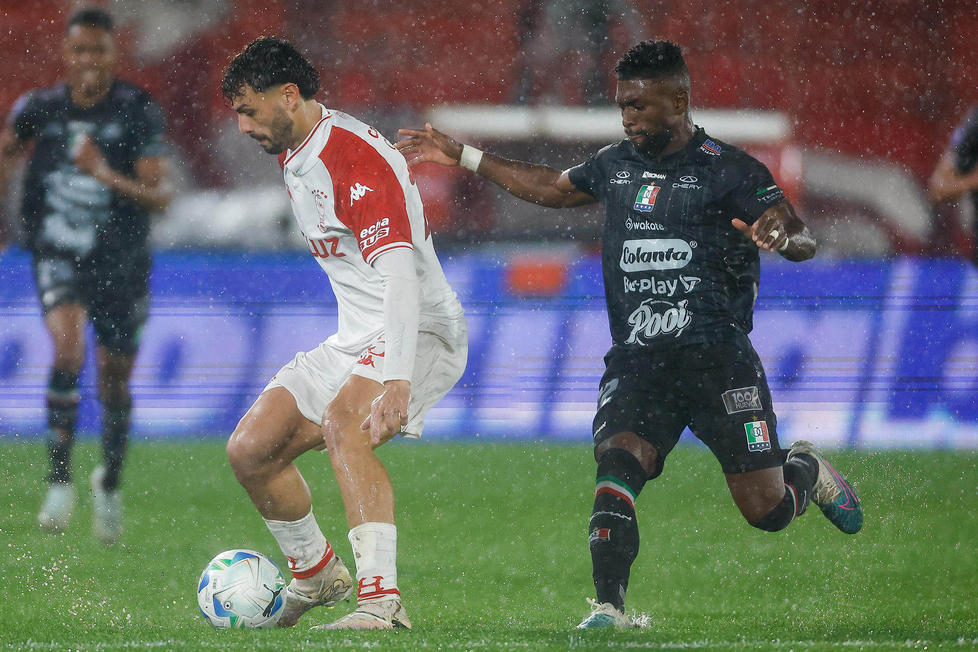 Luciano Giménez (i) de Huracán disputa el balón con Juan David Cuesta de Once Caldas este martes, durante un partido de octavos de final de la Copa Sudamericana. EFE/ Juan Ignacio Roncoroni
