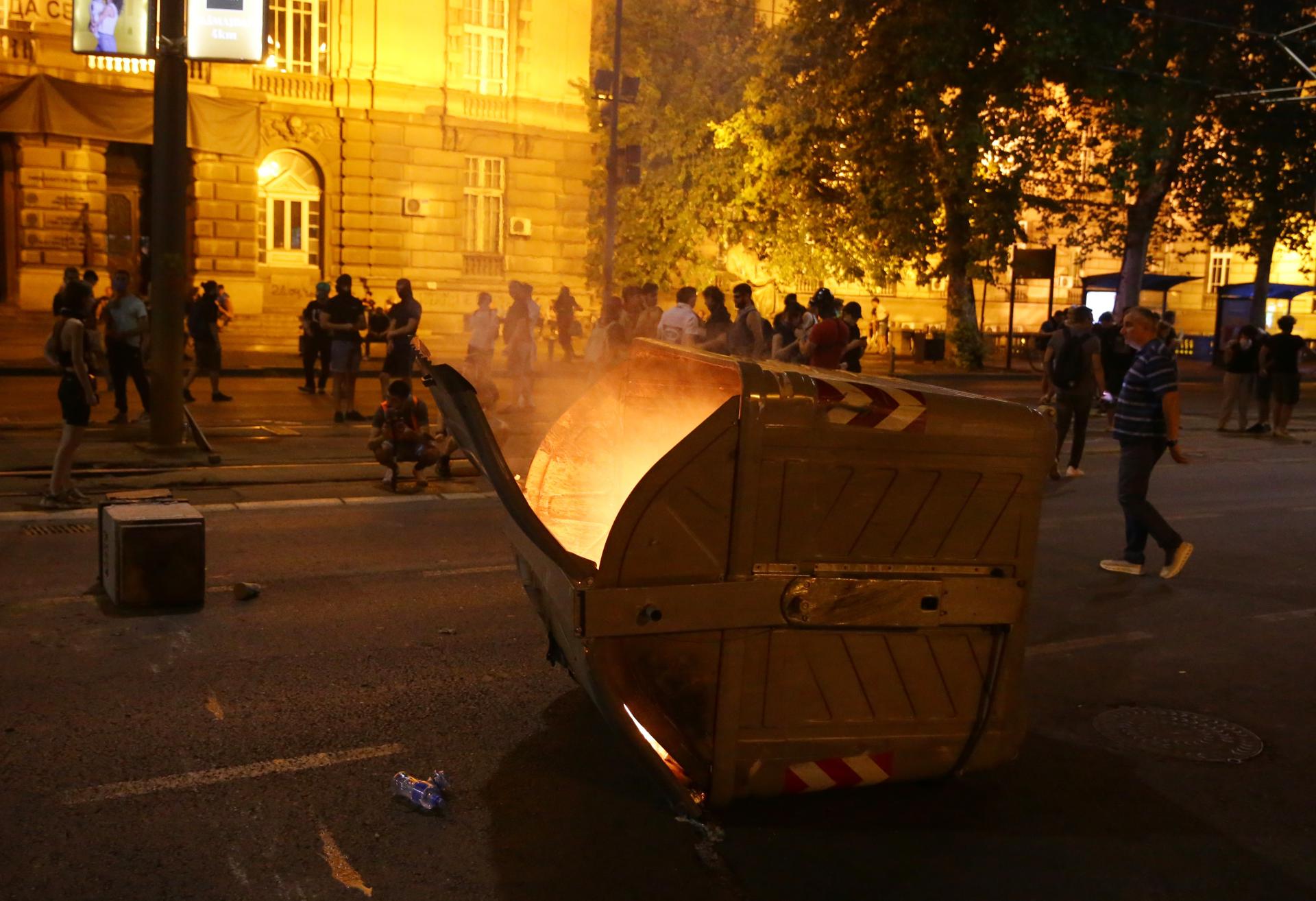 Manifestantes junto a un contenedor de basura volcado durante una protesta antigubernamental en Belgrado, el 18 de agosto de 2025. EFE/EPA/ANDREJ CUKIC