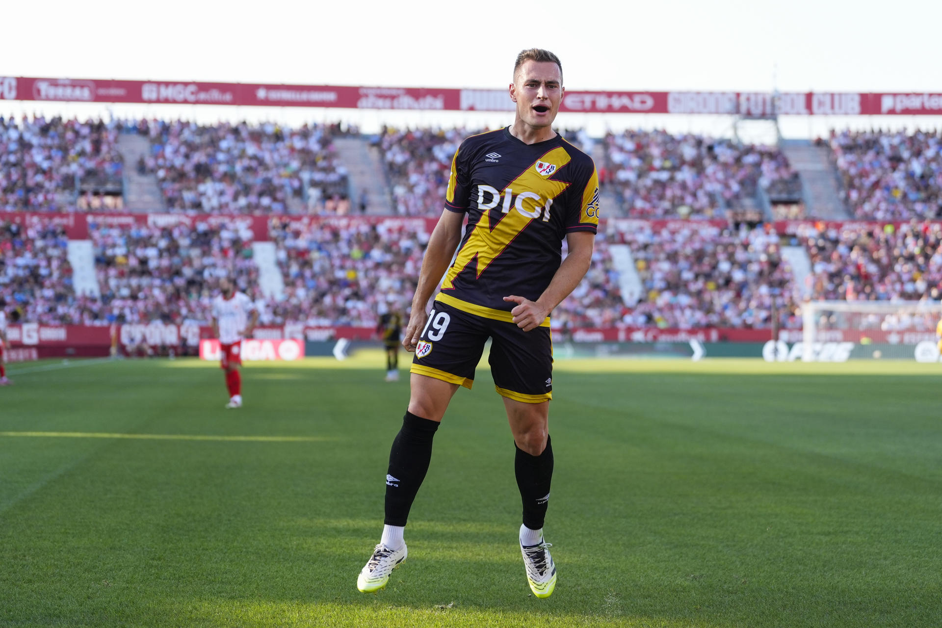 El delantero del Rayo Jorge de Frutos celebra tras anotar el primer gol del equipo durante el partido de la primera jornada de LaLiga que Girona CF y Rayo Vallecano disputan este viernes en el estadio Municipal de Montilivi. EFE/Siu Wu
