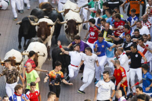 Los corredores son perseguidos por los toros durante el quinto encierro de San Sebastián de los Reyes este jueves. EFE/ David Fernández