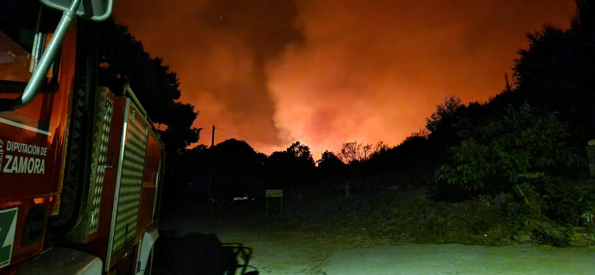 Un camión de bomberos de la Diputación durante los trabajos nocturnos de lucha contra el fuego y defensa de poblaciones en el incendio de Porto (Zamora). Los trabajos se centran en el entorno de la Sierra de la Cabrera, que marca el límite entre las provincias de Zamora y León, donde el lunes el fuego, avivado por el viento, saltó las defensas establecidas. EFE/Guardia Civil de Zamora // SOLO USO EDITORIAL/SOLO DISPONIBLE PARA ILUSTRAR LA NOTICIA QUE ACOMPAÑA (CRÉDITO OBLIGATORIO)