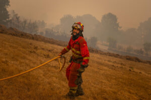 Un efectivo de la Unidad Militar de Emergencias (UME) lucha contra el fuego en la localidad de A Espasa, durante el incendio forestal que permanece activo en Chandrexa de Queixa (Ourense), este martes. EFE/Brais Lorenzo