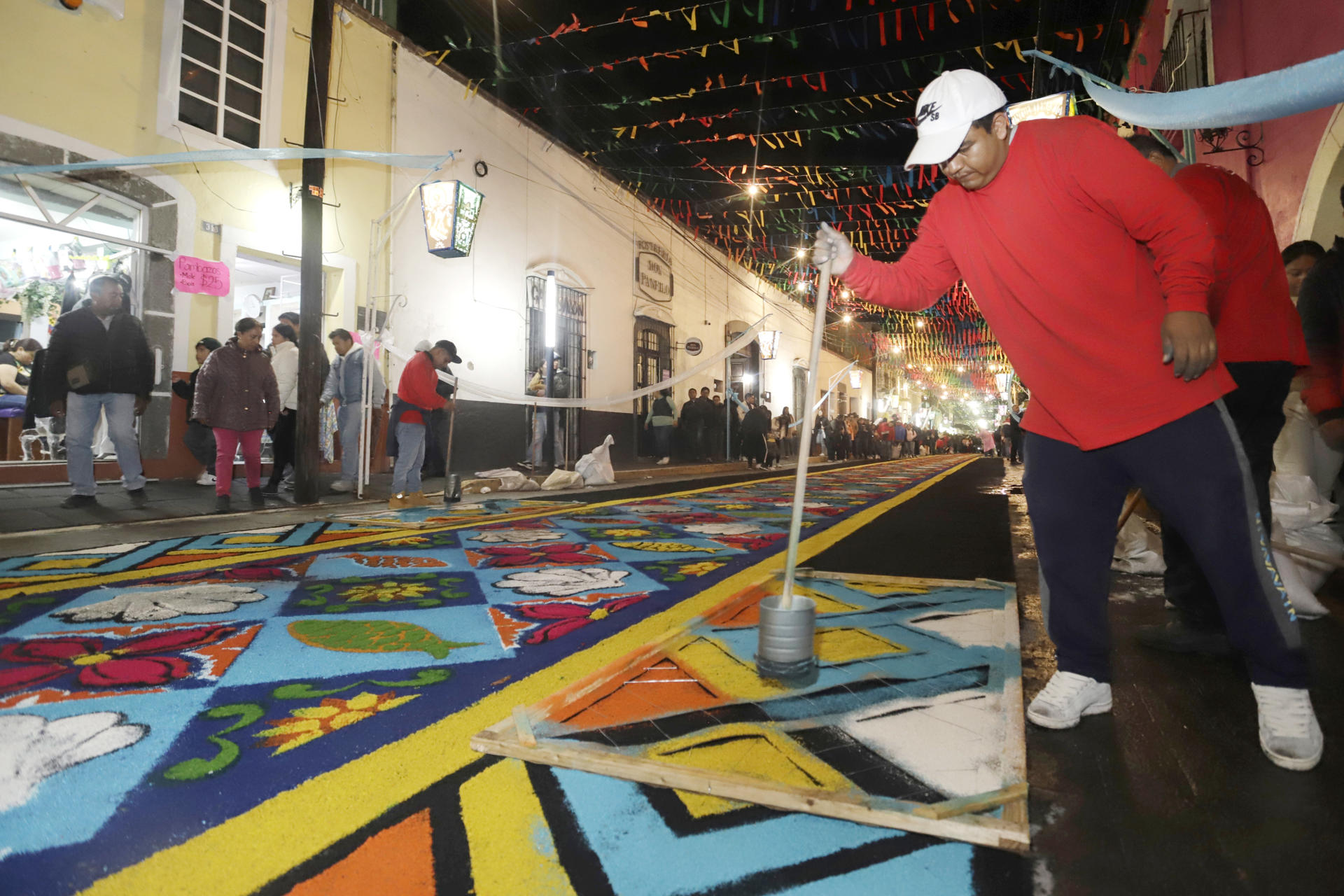 Artesanos adornan las calles con figuras y flores de aserrín durante la tradicional 'Noche que Nadie Duerme', en honor a la Virgen de la Caridad este viernes, en el municipio de Huamantla (México). EFE/ Hilda Ríos

