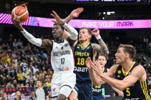 El base alemán Dennis Schroder (i) hace una penetración a canasta entre los suecos Viktor Gaddefors (c) y Wilhelm Falk (d), durante el partido del grupo B del Eurobasket 2025 entre ambas selecciones, disputado este viernes en Tampere (Finlandia). EFE/KIMMO BRANDT