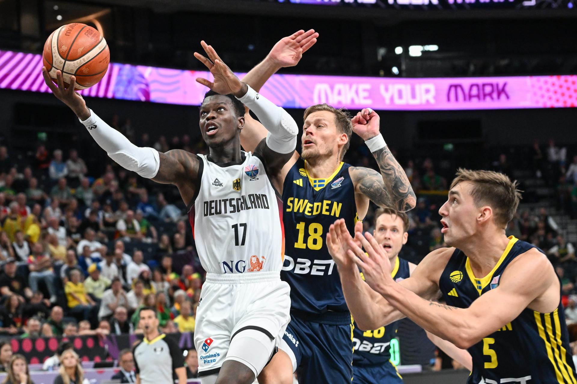El base alemán Dennis Schroder (i) hace una penetración a canasta entre los suecos Viktor Gaddefors (c) y Wilhelm Falk (d), durante el partido del grupo B del Eurobasket 2025 entre ambas selecciones, disputado este viernes en Tampere (Finlandia). EFE/KIMMO BRANDT