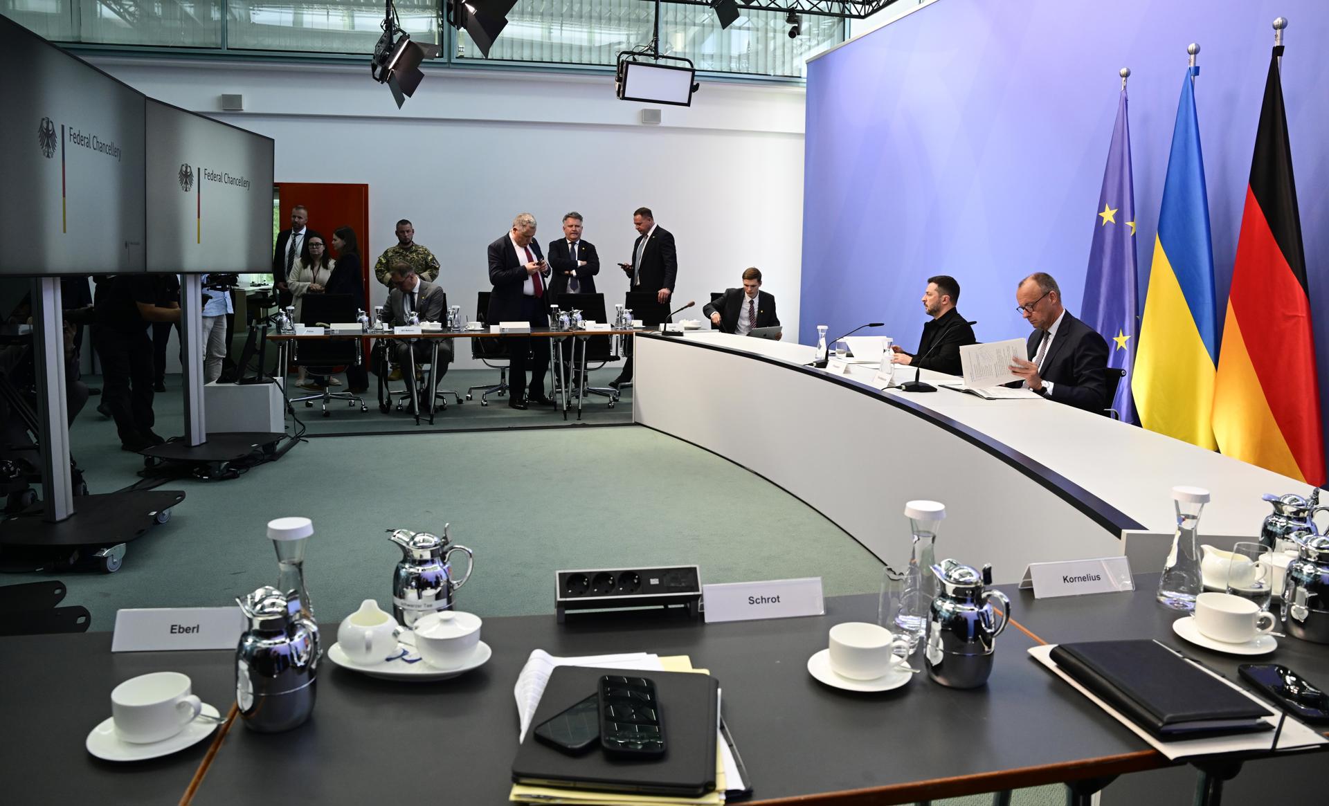 El presidente ucraniano Volodymyr Zelensky (2-R) y el canciller alemán Friedrich Merz (R) se sientan antes de una reunión en línea con otros líderes europeos para discutir la guerra en curso en Ucrania, en la Cancillería en Berlín, Alemania, 13 de agosto de 2025. (Alemania, Ucrania) EFE/EPA/JOHN MACDOUGALL / POOL