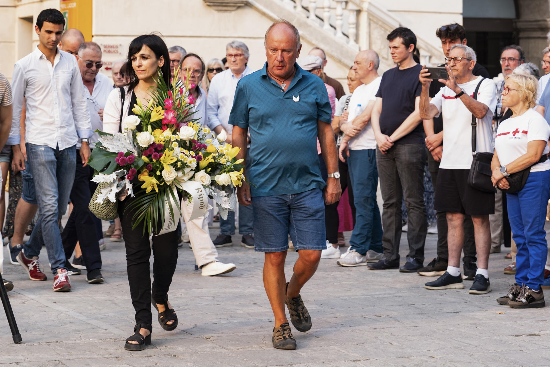 La alcaldesa de Ripoll, Silvia Orriols (i, delante), durante la ofrenda floral en homenaje a las víctimas de los atentados del 17-A, que causaron 16 muertos y más de un centenar de heridos, en el octavo aniversario del ataque, este domingo en Ripoll (Barcelona). EFE/Siu Wu