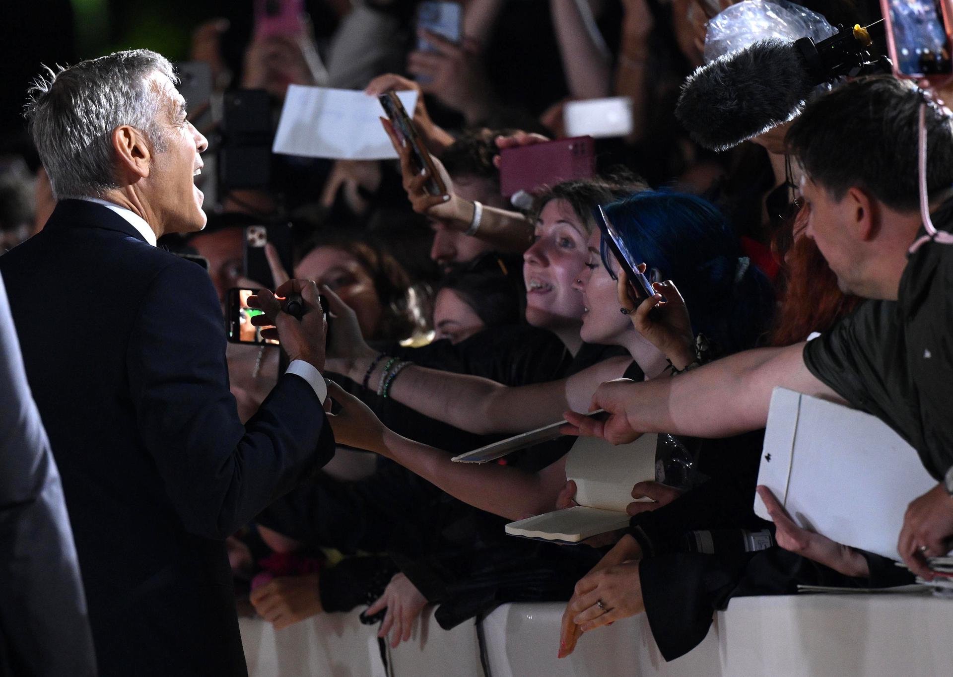 El actor estadounidense George Clooney (i), al firmar autógrafos, tras su llegada a la premiere de la cinta 'Jay Kelly', durante la 82ª edición del Festival Internacional de Cine de Venecia, en Venecia (Italia) EFE/Ettore Ferrari