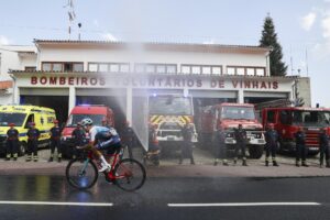 Fotografía de Tiago Petinga, en la que puede verse a una dotación de bomberos refrescando el paso de los ciclistas de la Vuelta a Portugal este sábado. EFE