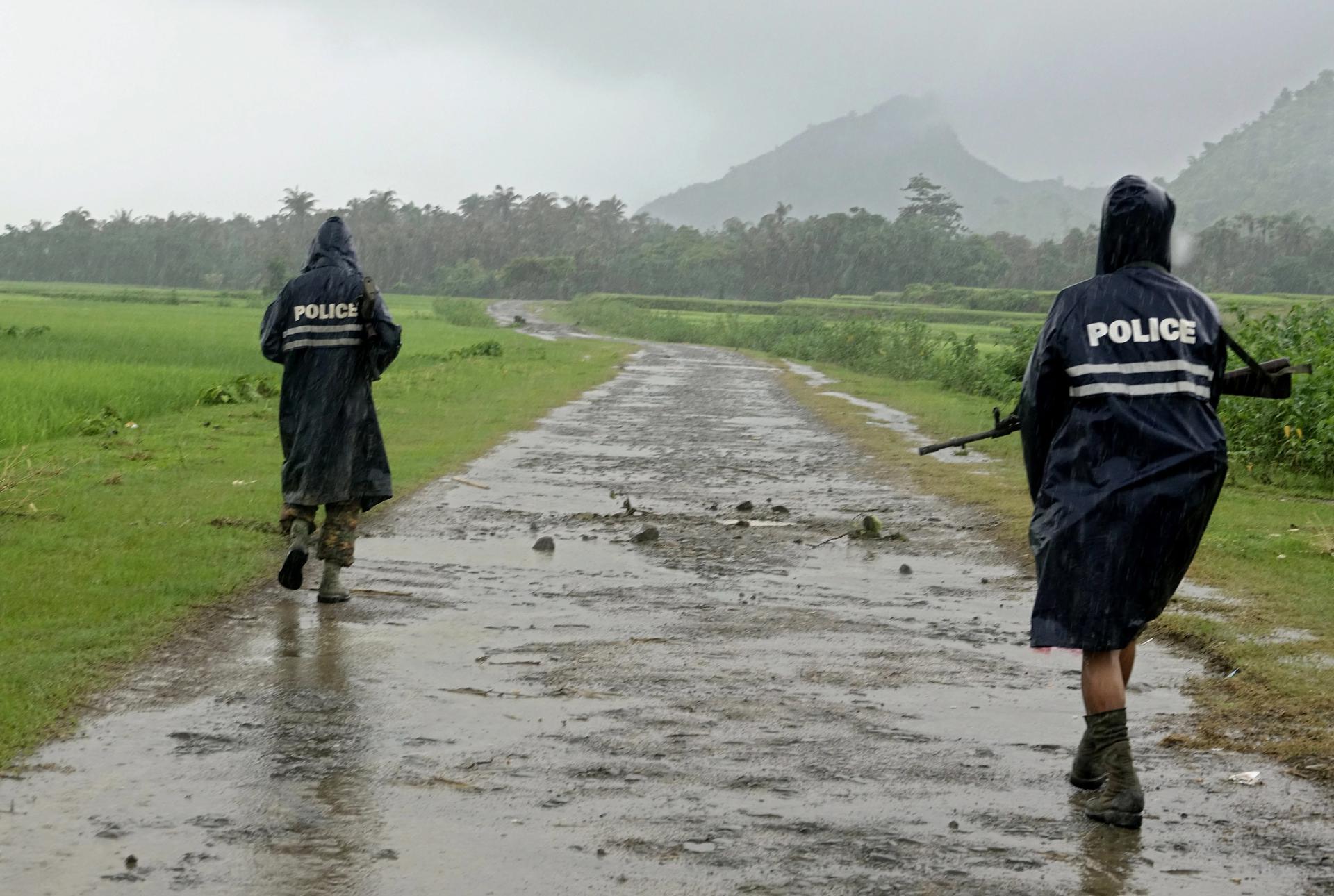 Archive. NW015. Rathedaung (Myanmar), 26/08/2017.- Myanmar police officers in rain coats patrol on a road in the etnic Rakhine village of ChainKharLi, an area close to fighting at Rathedaung township of northern Rakhine State, western Myanmar, 26 August 2017. According to a statement by the Myanmar Armed Forces, at least 32 people, including eleven law enforcement officials, were killed on 25 August in Myanmar after Rohingya militants attacked police outposts and an army base in the western state of Rakhine. (Birmania, Atentado) EFE/EPA/NYUNT WIN