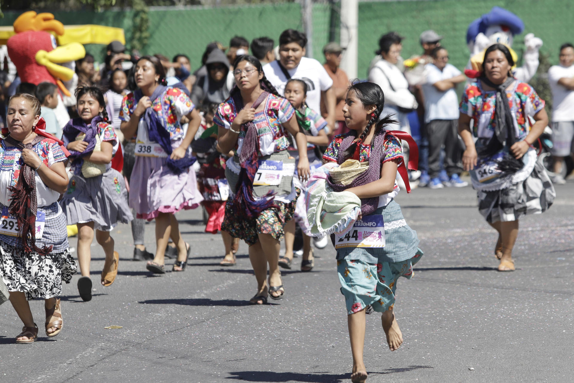 Mujeres de distintas edades participan con sus trajes tradicionales en la 'Carrera de la Tortilla' este domingo, en Santa Maria Coapan, en el estado de Puebla (México). EFE/ Hilda Ríos
