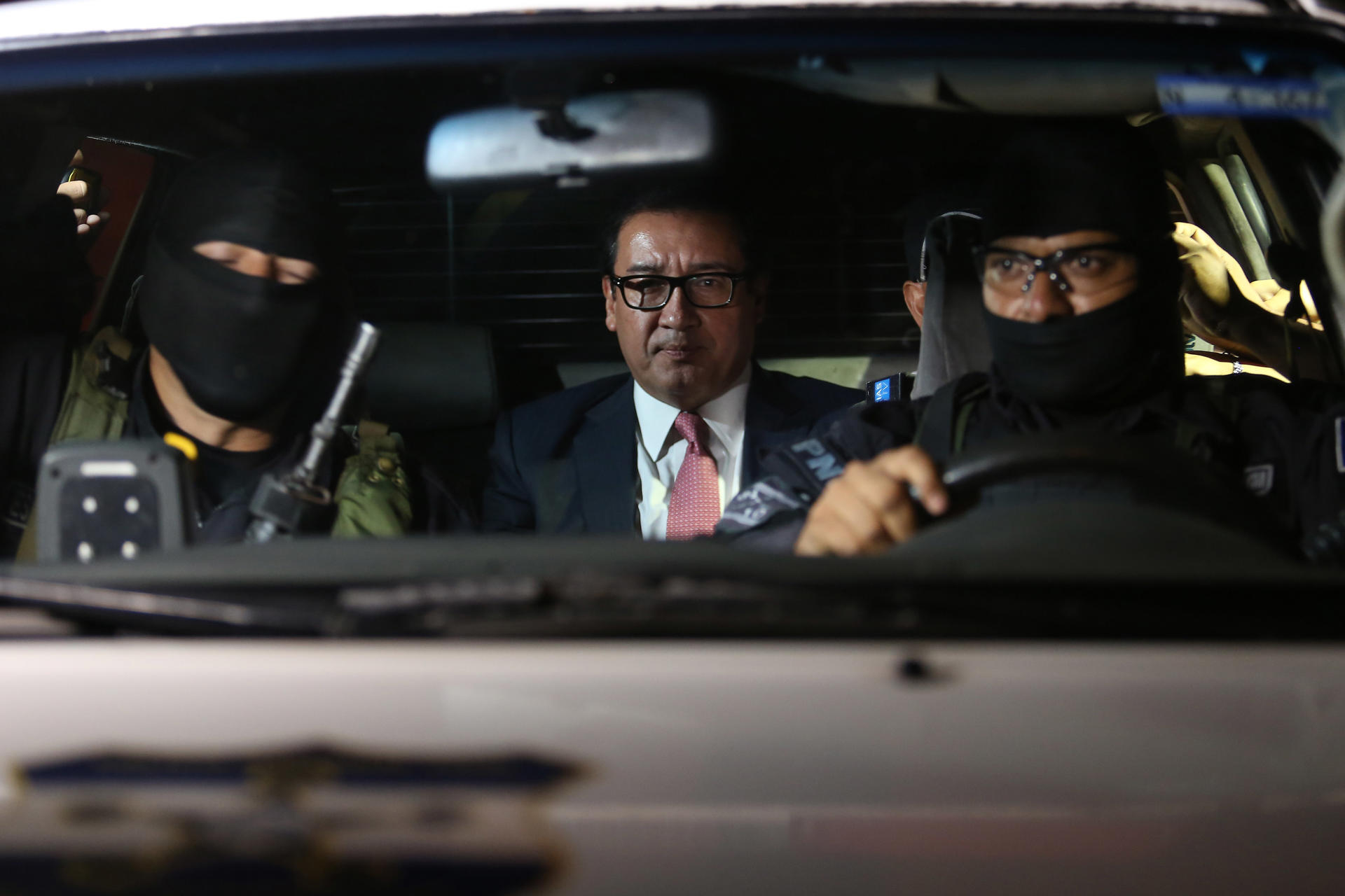 Fotografía de archivo en la que se captó al exfiscal general de El Salvador entre 2012 y 2015, Luis Martínez (c), al ser conducido por autoridades, en San Salvador. EFE/Rodrigo Sura
