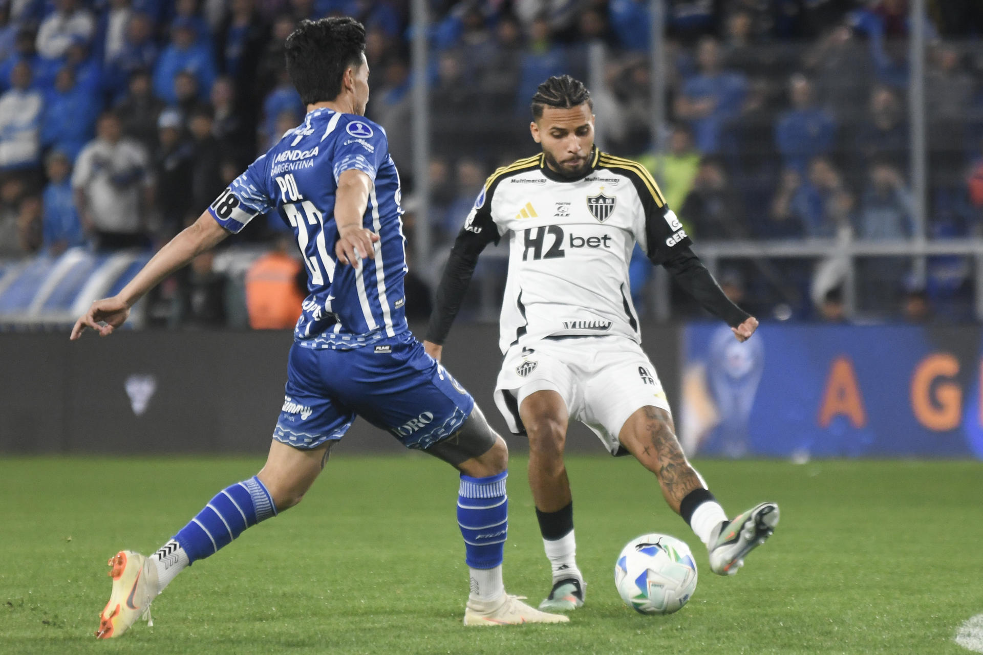 Guillermo Matías Fernández (i) de Godoy Cruz disputa el balón con Alexsander Christian Gomes da Costa de Atlético Mineiro en un partido de los octavos de final de la Copa Sudamericana. EFE/ Ramiro Gómez
